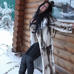 Mistress in fur and boots plays with her slave in the snow